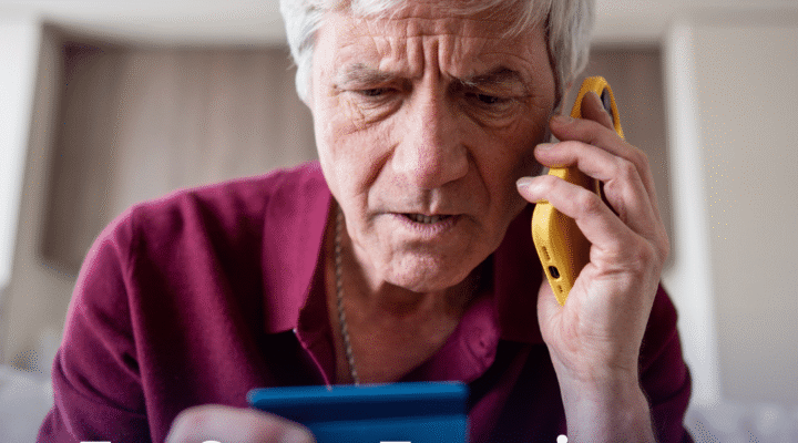Senior man on the phone looking concerned while reviewing a credit card, representing common scams targeting seniors in 2026